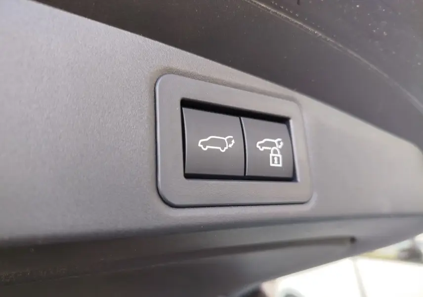 Gros plan sur les boutons d'ouverture et de verrouillage du hayon du Toyota Corolla Touring Sport gris Atlas 2026.