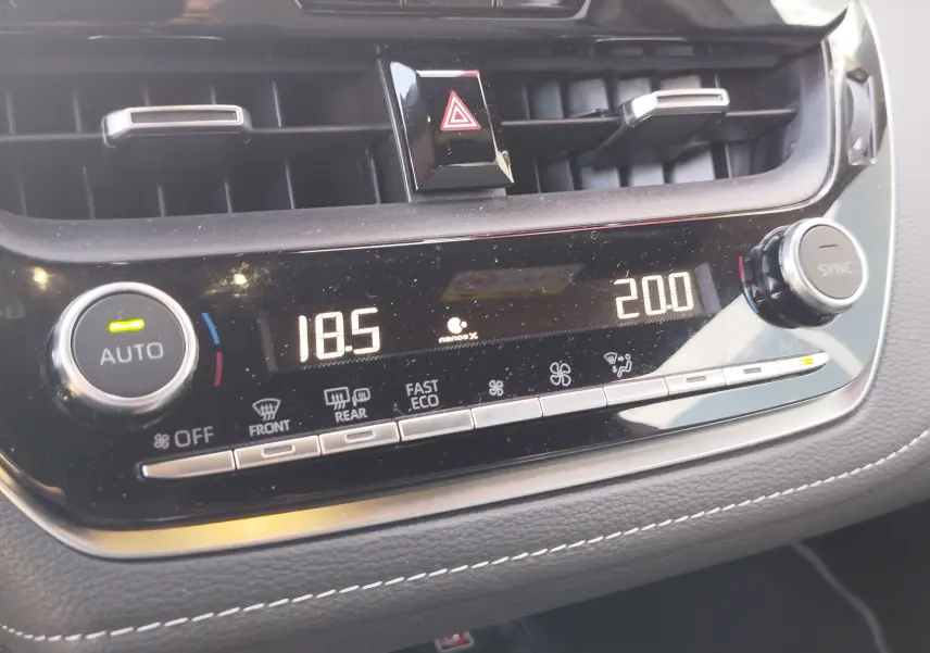 Détail de la console centrale de la Toyota Corolla Touring Sport 2026, affichage numérique de la climatisation bi-zone.