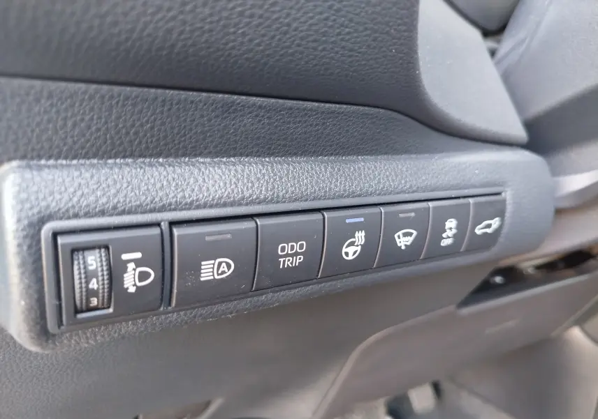 Gros plan sur les commandes latérales noires du tableau de bord de la Toyota Corolla Touring Sport gris Atlas.