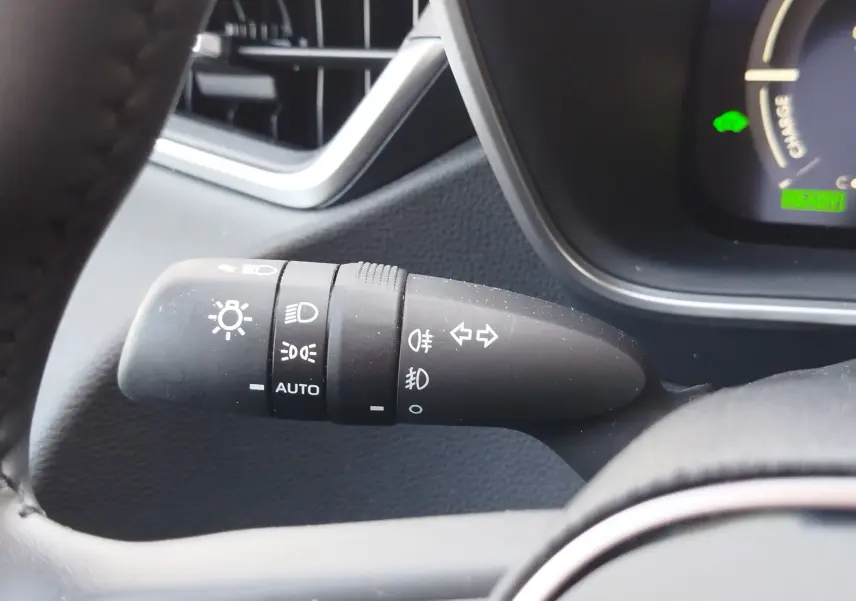 Gros plan sur la manette de commande des feux et clignotants dans l’habitacle gris foncé de la Toyota Corolla Touring Sport 2026.