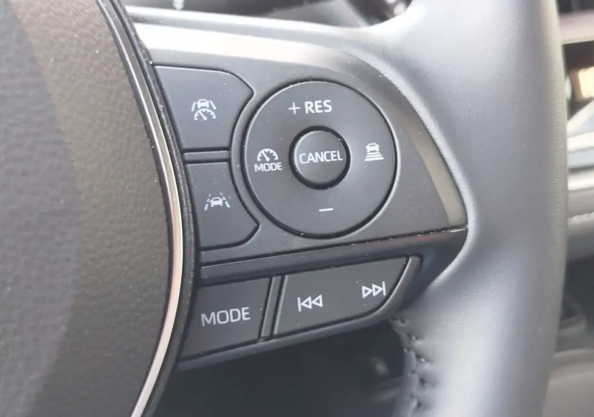 Gros plan sur les commandes au volant à droite de la Toyota Corolla Touring Sport 2026, boutons de régulateur et multimédia.