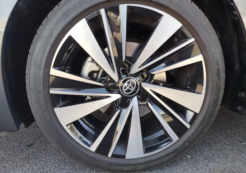 Gros plan sur la jante alliage bicolore noir et argent avec logo Toyota au centre, roue avant droite.
