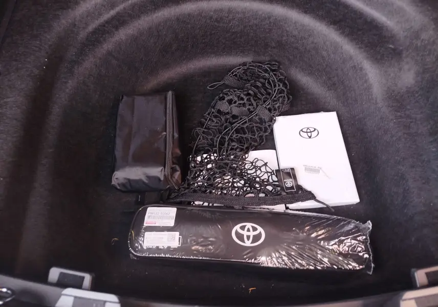 Vue plongeante sur le coffre noir d'une Toyota Corolla Touring Sport 2026 avec accessoires Toyota rangés.