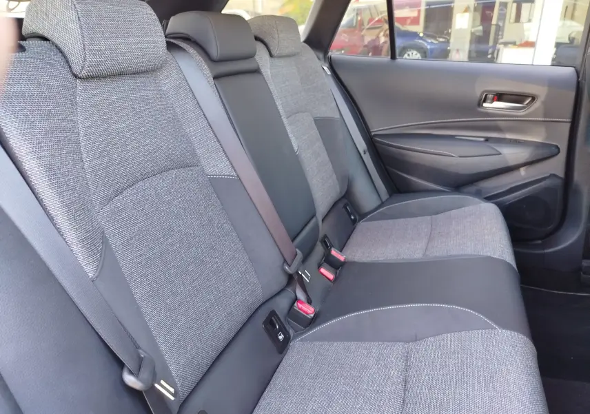 Vue intérieure côté droit des sièges arrière en tissu gris et noir de la Toyota Corolla Touring Sport 2026.