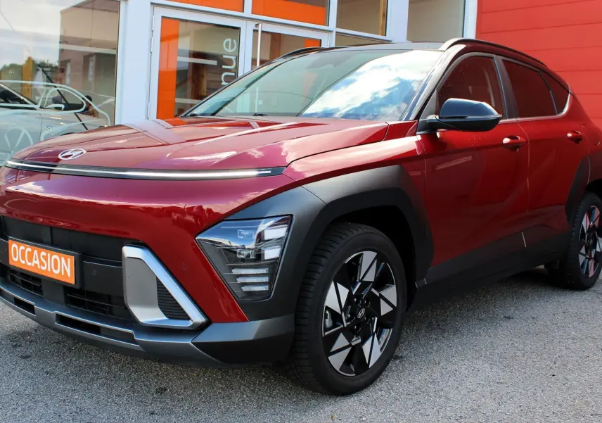 Hyundai Kona hybride rouge Ultimate Metal vu en 3/4 avant droit avec détails noirs et jantes bicolores.