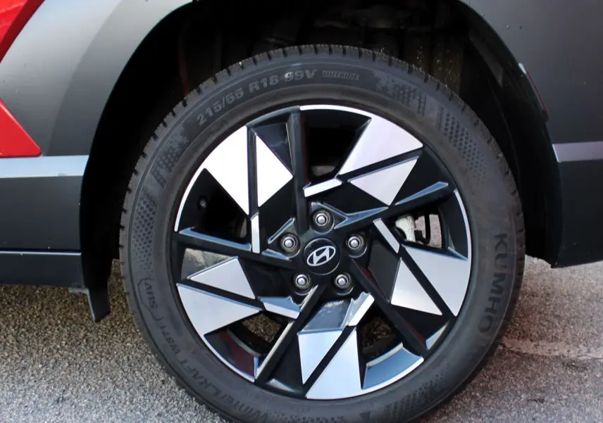 Gros plan sur la roue arrière droite du Hyundai Kona 2024 rouge Ultimate Metal avec jante alliage noire et argentée.