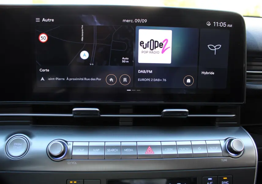 Vue rapprochée de l’écran tactile et des commandes centrales du Hyundai Kona 2024, affichant navigation et radio.