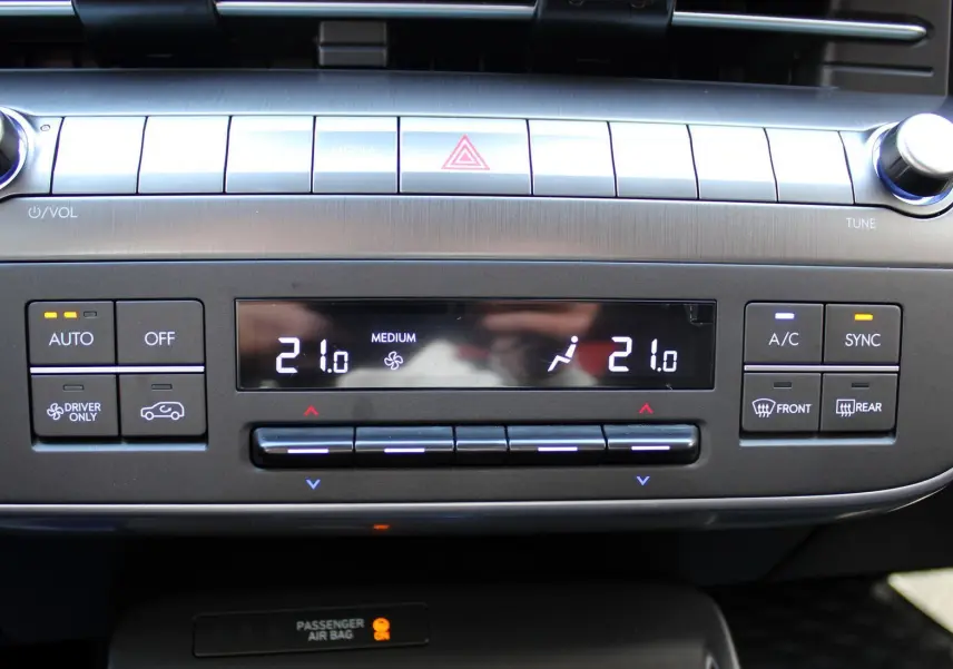 Vue rapprochée du tableau de bord de la Hyundai Kona 2024, affichant la climatisation digitale à 21°C.