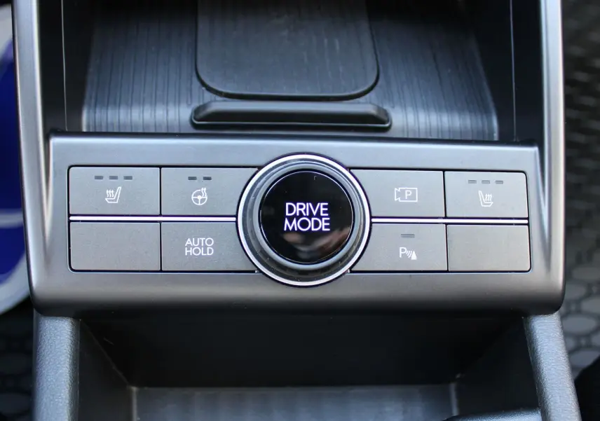 Gros plan sur la console centrale du Hyundai Kona 2024, montrant le bouton rotatif Drive Mode et commandes de sièges chauffants.