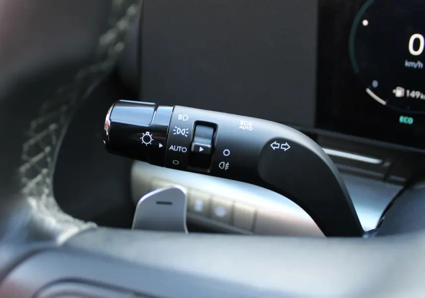 Gros plan sur la commande des feux et clignotants à gauche du volant dans un Hyundai Kona 2024 hybride.