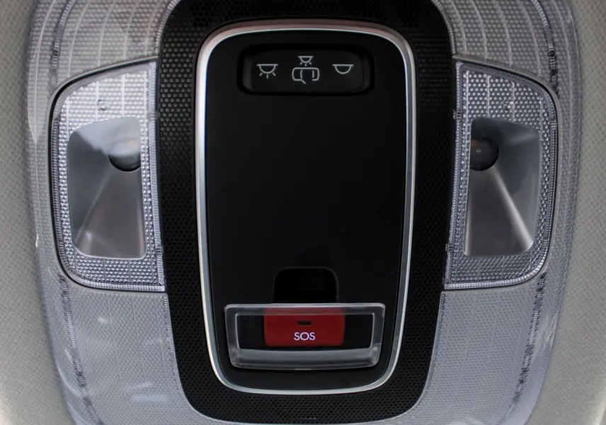 Vue en gros plan du plafonnier intérieur du Hyundai Kona 2024 avec bouton SOS rouge et éclairages LED transparents.