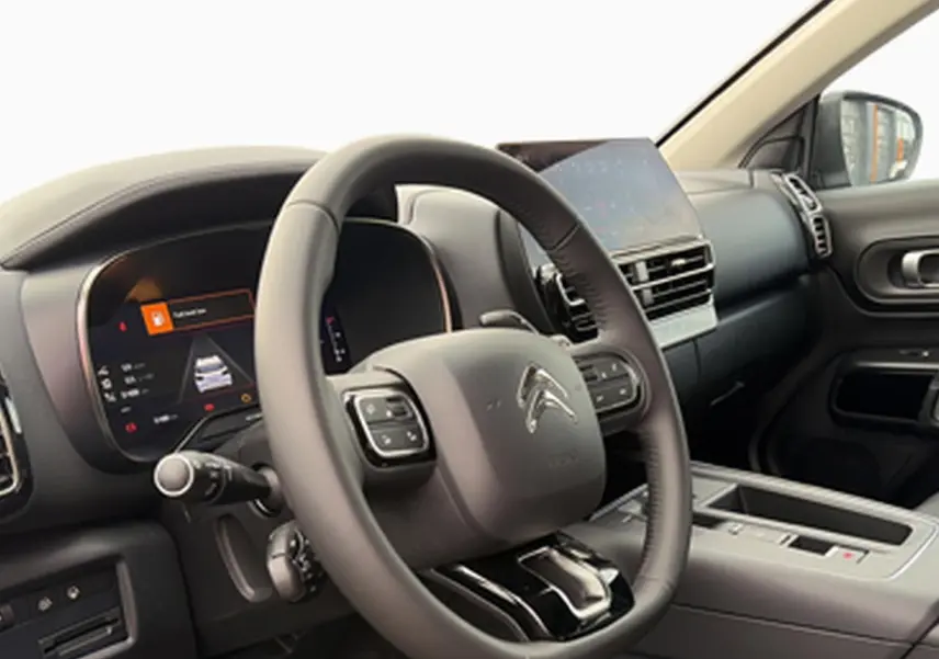 Vue intérieure du poste de conduite du Citroën C5 Aircross noir, volant cuir multifonction et écran tactile central.