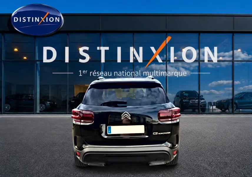 Vue arrière d'un Citroën C5 Aircross noir 2025, avec feux LED et barres de toit visibles devant un showroom Distinxion.
