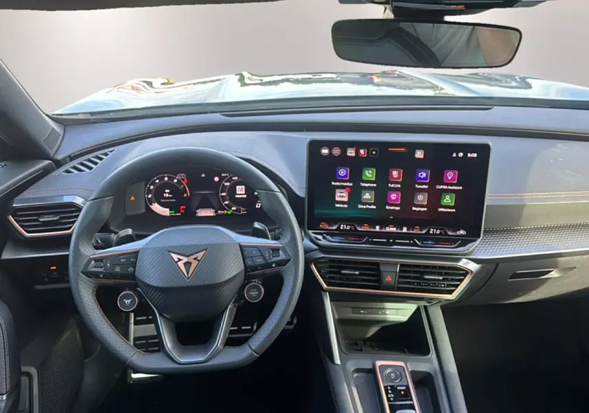 Vue intérieure avant du tableau de bord et volant cuir sport du CUPRA Formentor bleu fjord avec écran tactile central.