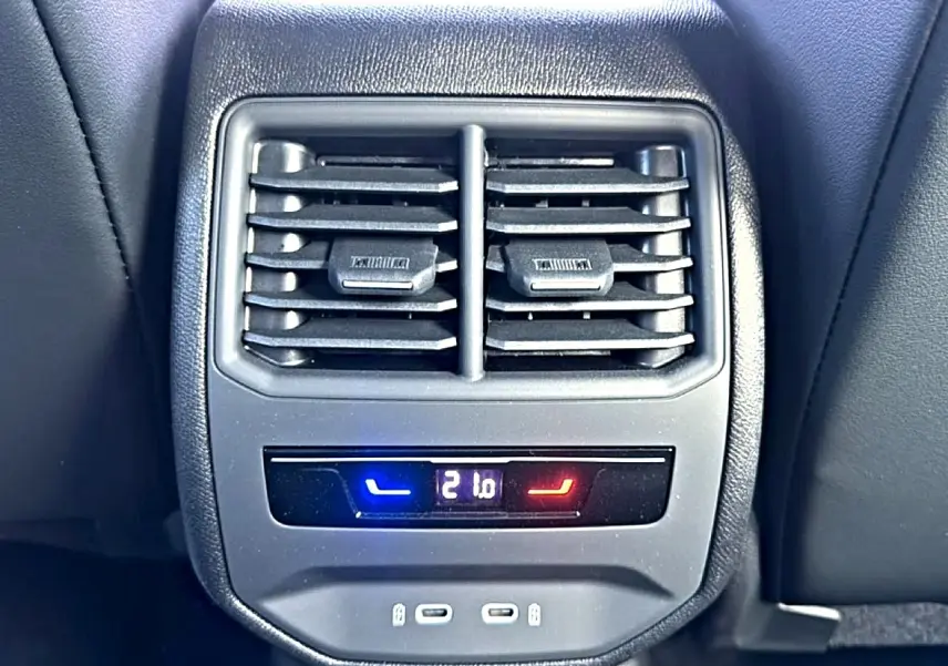 Vue rapprochée de la console arrière du CUPRA Formentor bleu fjord avec bouches d’aération et commande climatisation digitale.