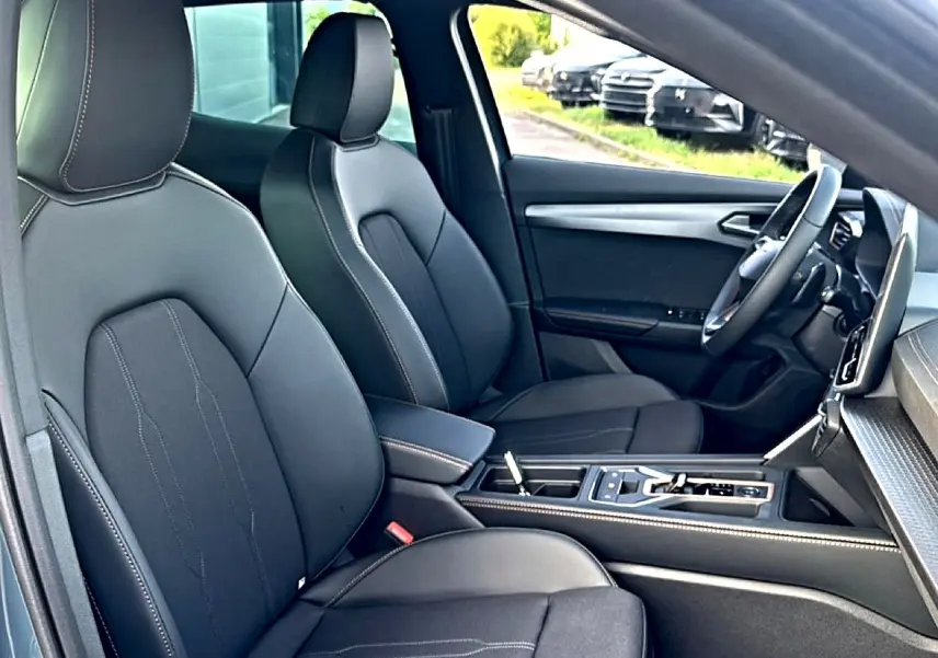 Vue intérieure côté conducteur du CUPRA Formentor 2026, sièges sport noirs avec surpiqûres contrastées et console centrale moderne.
