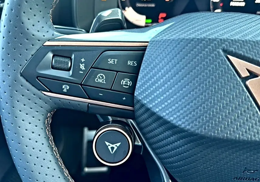 Gros plan sur le volant cuir perforé de la CUPRA Formentor 2026 avec commandes multifonctions et logo distinctif.