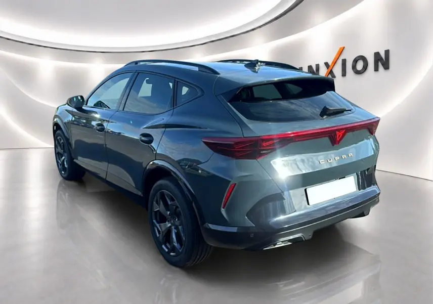 Vue 3/4 arrière droite d'un CUPRA Formentor 1.5 etsi hybrid bleu fjord avec feux arrière LED et jantes noires.
