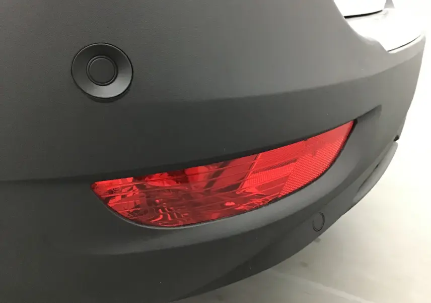 Gros plan sur le feu arrière droit et le pare-chocs noir d'un Peugeot 5008 blanc nacré de 2021.