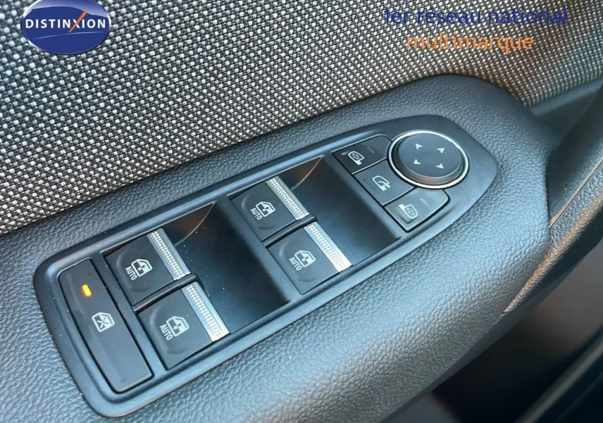 Gros plan sur les commandes des vitres électriques et réglages des rétroviseurs côté conducteur du Renault Captur blanc nacré.