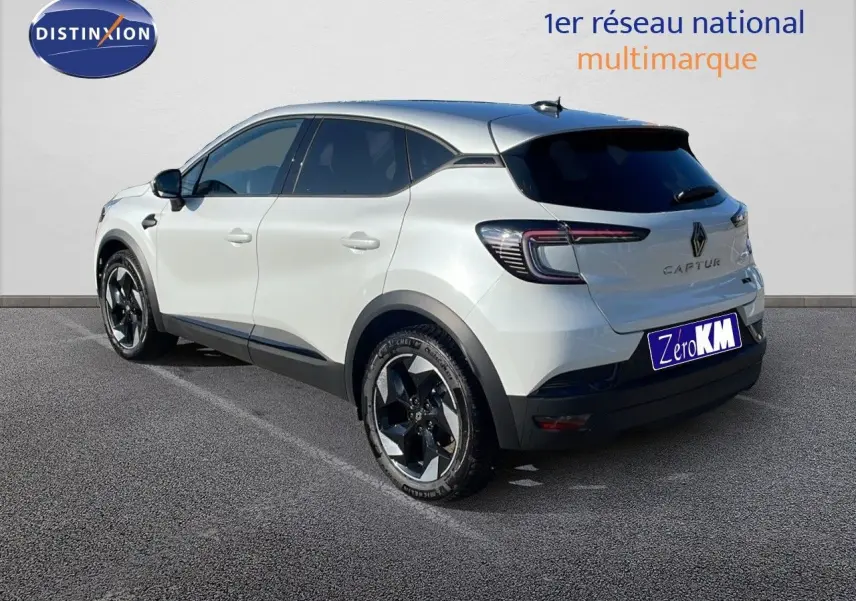 Vue 3/4 arrière droite d'un Renault Captur blanc nacré avec toit gris, jantes noires et feux LED distinctifs.