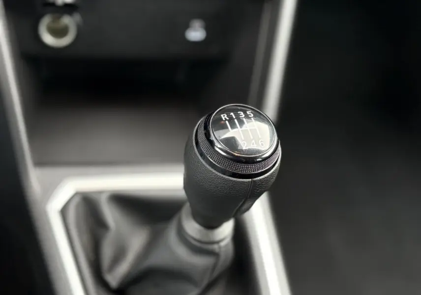Gros plan sur le levier de vitesses manuel noir du Dacia Jogger 2025, avec indication des six rapports et marche arrière.