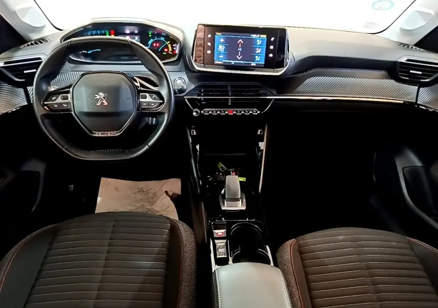 Vue intérieure avant du tableau de bord et volant cuir noir de la Peugeot 208 électrique Active Business 2021.