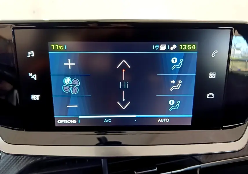 Écran tactile central affichant le réglage de la climatisation dans une Peugeot 208 électrique blanche, vue de face.