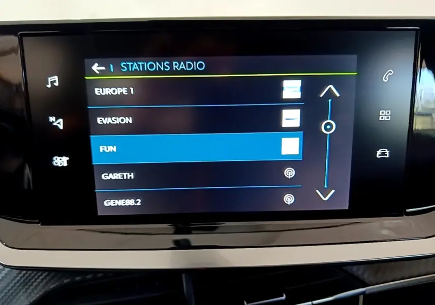 Écran tactile central affichant les stations radio dans l’habitacle d’une Peugeot 208 électrique blanche.