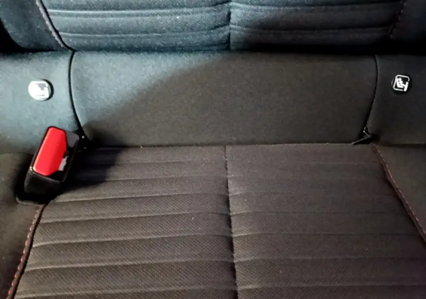 Gros plan sur la banquette arrière noire avec ceinture rouge et fixations Isofix d'une Peugeot 208 Electrique Active Business.