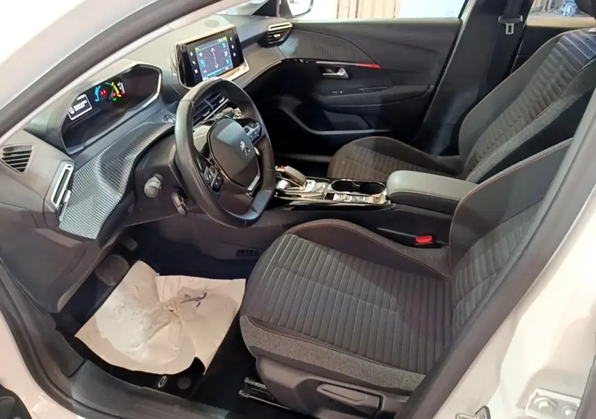 Intérieur avant droit de la Peugeot 208 Electrique Active Business 2021, sièges gris et volant cuir multifonctions.
