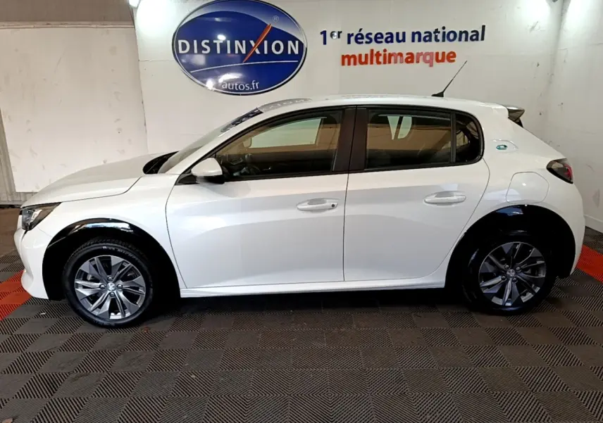 Peugeot 208 électrique blanche vue de profil côté gauche, avec jantes alliage et logo Distinxion en arrière-plan.