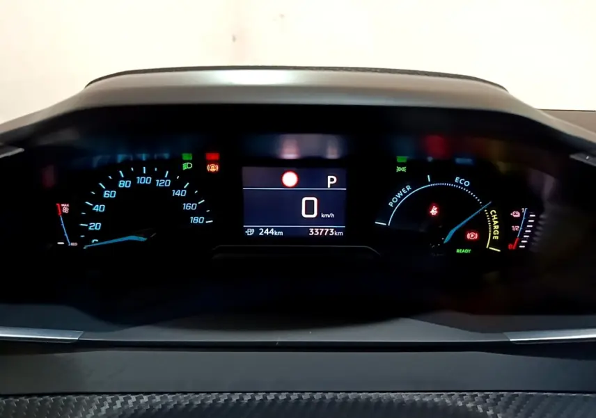 Vue rapprochée du tableau de bord numérique de la Peugeot 208 électrique, affichage vitesse, autonomie et indicateurs énergie.