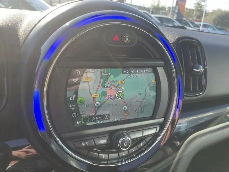 Vue rapprochée du tableau de bord du MINI Countryman bleu 2018, avec écran de navigation et anneau lumineux bleu.