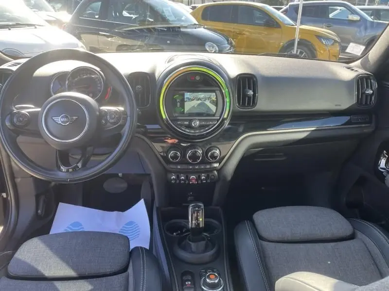 Vue intérieure avant de la MINI Countryman Cooper D 2018, tableau de bord noir avec écran central rond et volant multifonction.