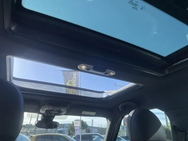 Vue intérieure du toit ouvrant panoramique du MINI Countryman Cooper D 2018 bleu, avec ciel visible à travers le verre.
