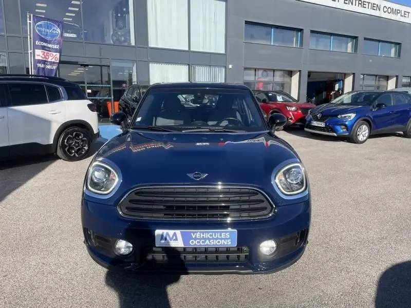 Vue de face d'une MINI Countryman Cooper D bleu foncé, avec calandre noire et plaque "Véhicules Occasions" visible.