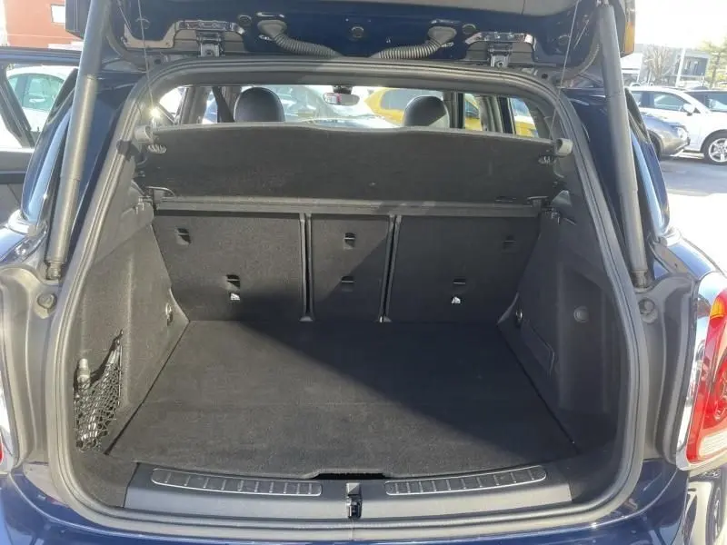 Coffre ouvert en vue arrière d’un MINI Countryman bleu 2018, espace de chargement spacieux et tapis noir visible.