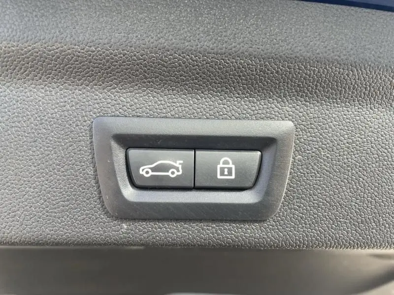 Boutons d'ouverture du coffre et de verrouillage intégrés dans le panneau intérieur noir d'une MINI Countryman 2018.