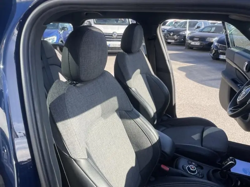 Vue intérieure côté conducteur du MINI Countryman Cooper D 2018 bleu, sièges tissu et cuir Oakwood, console centrale visible.