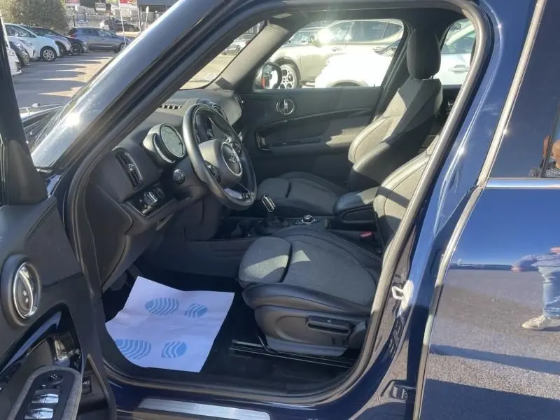 Vue intérieure côté conducteur d'une MINI Countryman bleu 2018, montrant les sièges et le tableau de bord.