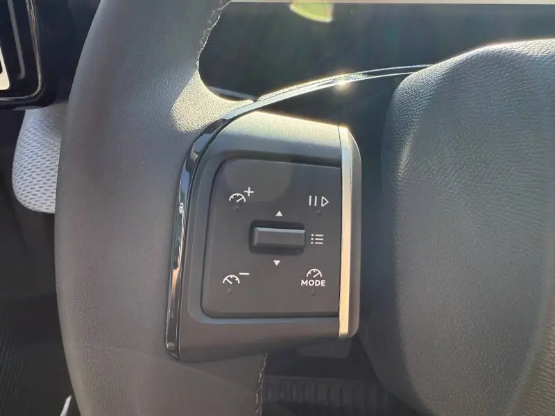 Gros plan sur les commandes de régulateur de vitesse au volant noir de la Citroën C3 électrique 2025.