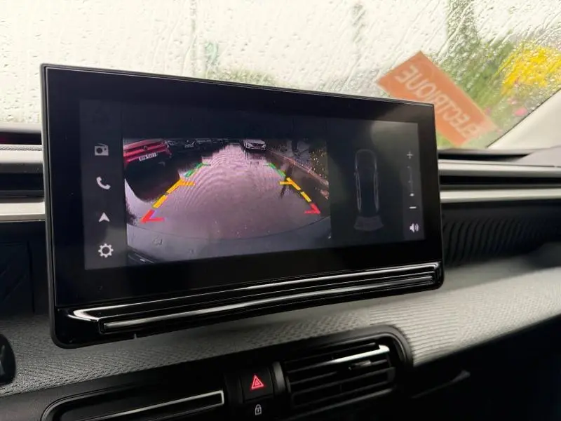 Écran tactile intérieur de la Citroën C3 électrique 2025 montrant la caméra de recul sous pluie.