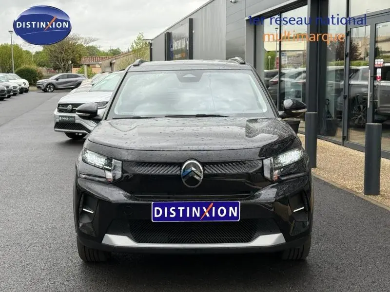 Vue de face d'une Citroën C3 électrique 2025 en noir Perla Nera, avec phares LED allumés et calandre épurée.