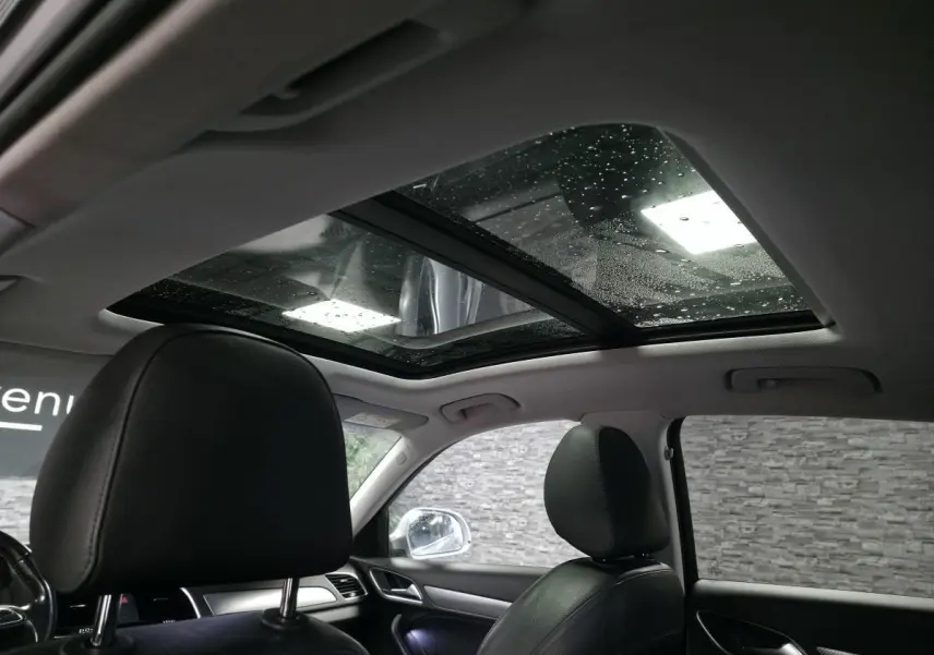 Vue intérieure de l'Audi Q3 2016 avec toit ouvrant panoramique et sièges en cuir noir.