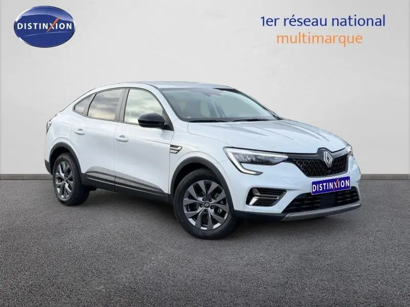 Renault Arkana blanc en 3/4 avant droit, avec calandre noire et jantes alliage gris foncé visibles.