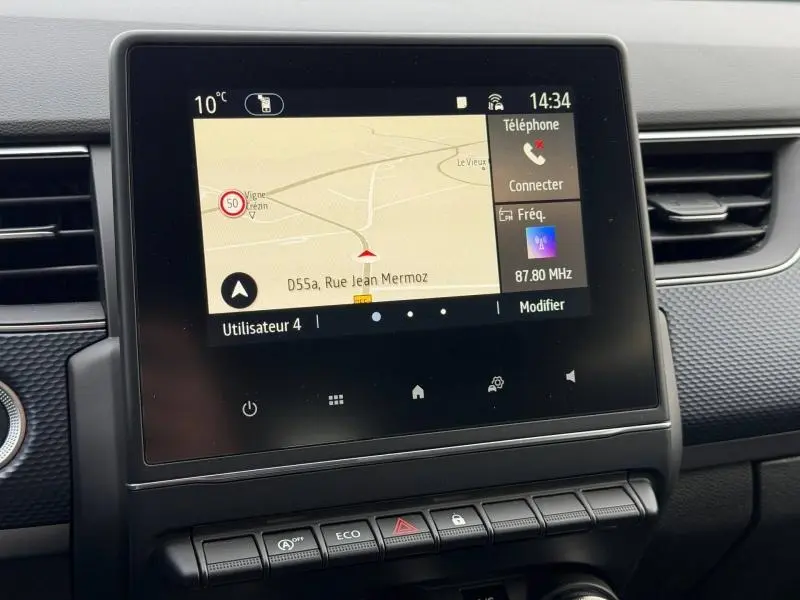 Écran tactile central du tableau de bord du Renault Arkana blanc 2025 affichant la navigation et les commandes multimédia.