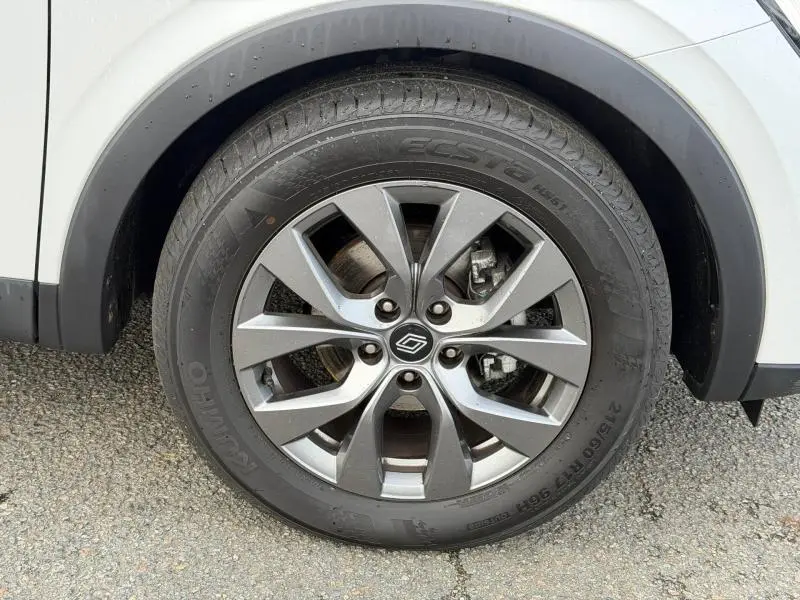 Gros plan sur la roue avant droite du Renault Arkana blanc 2025 avec jante alliage gris à 5 doubles branches.