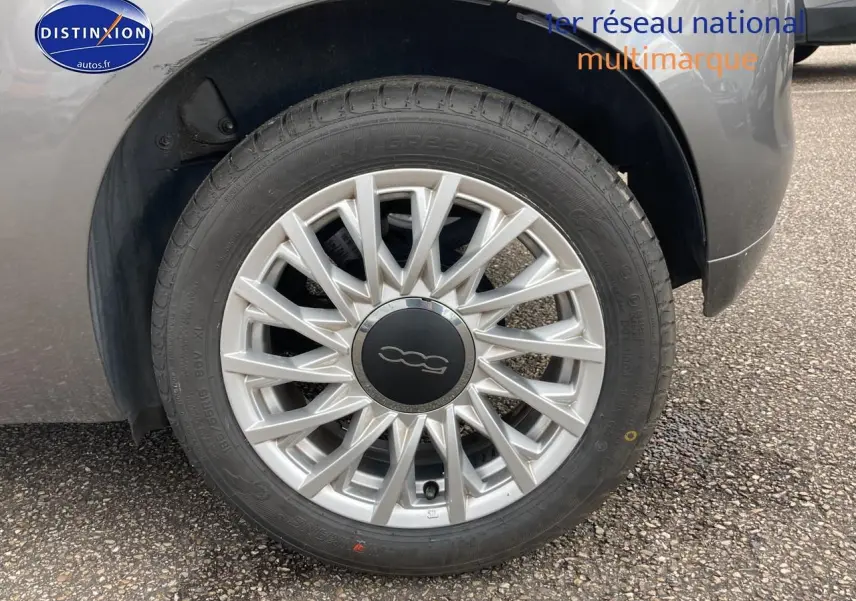 Gros plan sur la roue avant gauche gris métallisé d'une FIAT 500 1.0 70 bsg dolcevita avec jante alu distinctive.