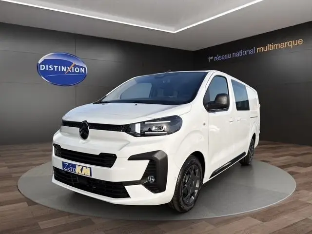 Citroën Jumpy XL blanc vu en 3/4 avant droit, avec calandre noire et jantes foncées, en showroom intérieur.